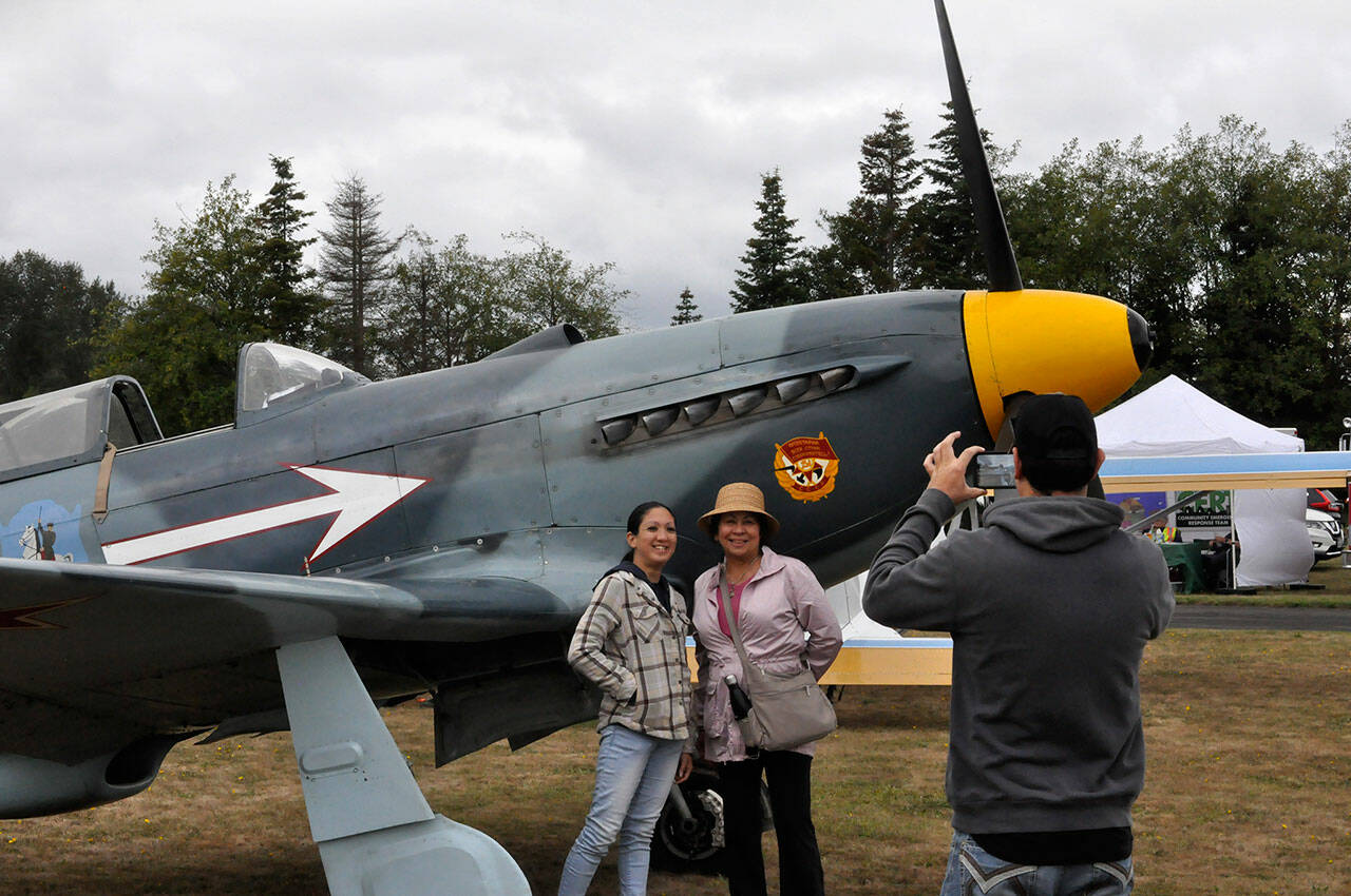 Sequim Gazette photos by Matthew Nash
Josh Crane of Sequim snaps a picture of his girlfriend Raechel Hayashi and his mom Kathleen Crane of Greenville, South Carolina at the Olympic Peninsula Air Affaire on Aug. 24. They stand by Bill Shepherd’s Yak-3, a reproduction World War II Russian airplane.