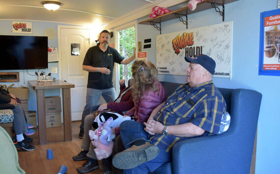 Tom Waertz of Ready America, left, runs an earthquake simulation in a shake trailer as participants, from left, Sequim EMT Lisa Law, CERT member Anne Koepp of Joyce and Jim Buck of the Joyce Emergency Planning and Preparation Group recover after being jolted by a 6.8-magnitude quake. (Keith Thorpe/Peninsula Daily News)