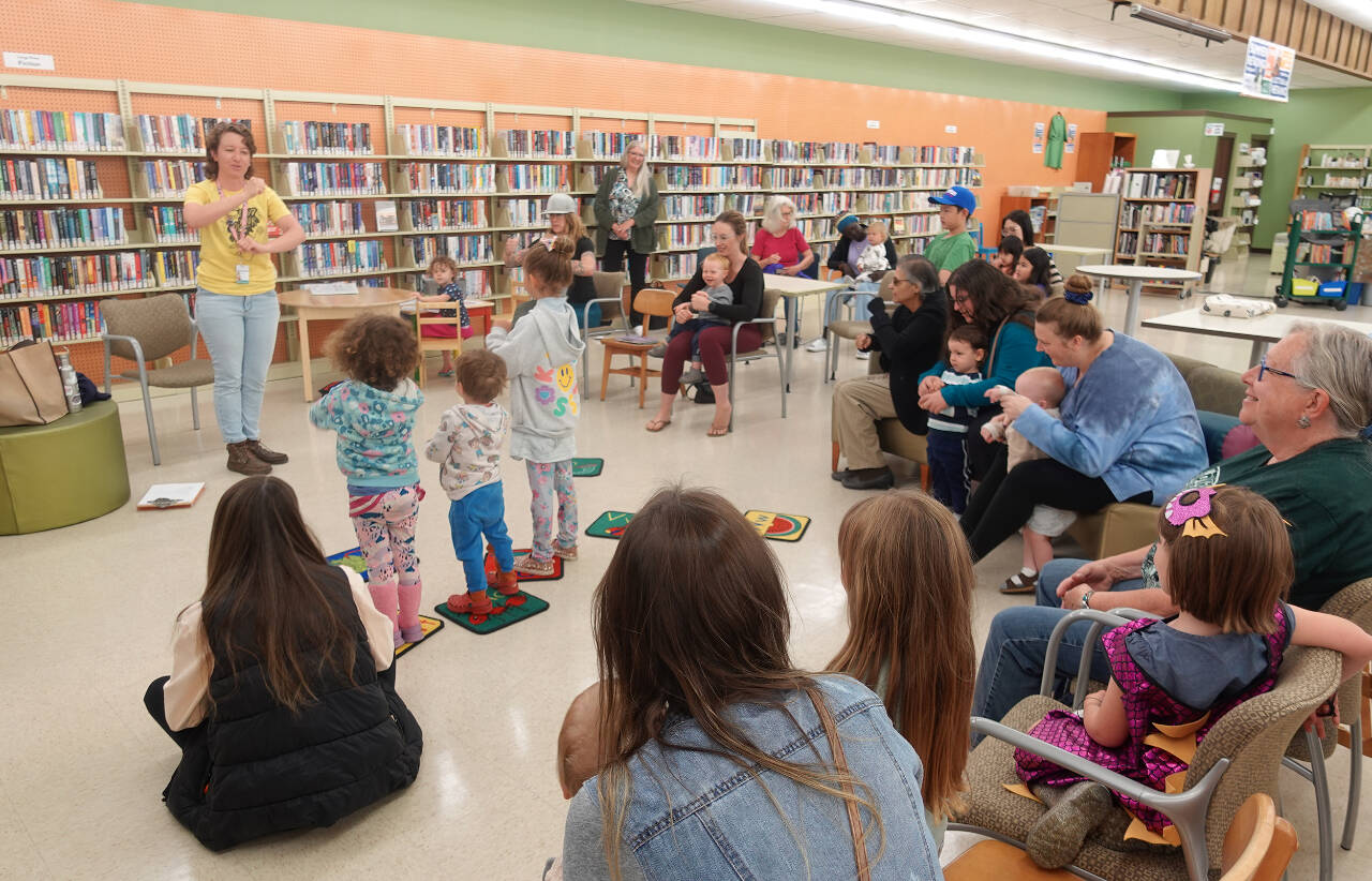 Photo courtesy of North Olympic Library System / At left, Charlotte McGrew — youth services librarian for the North Olympic Library System, leads a Family Storytime program. Free fall programs for all ages begin in September at the Sequim Library.