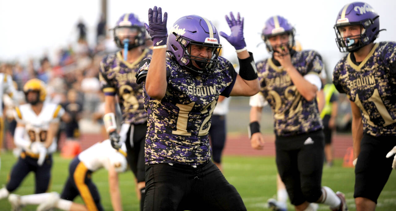 Sequim Gazette photo by Michael Dashiell / Sequim High running back Liam Wiker celebrates the first of two touchdowns in the Wolves’ season-opening 35-26 win over Forks on Sept. 6.