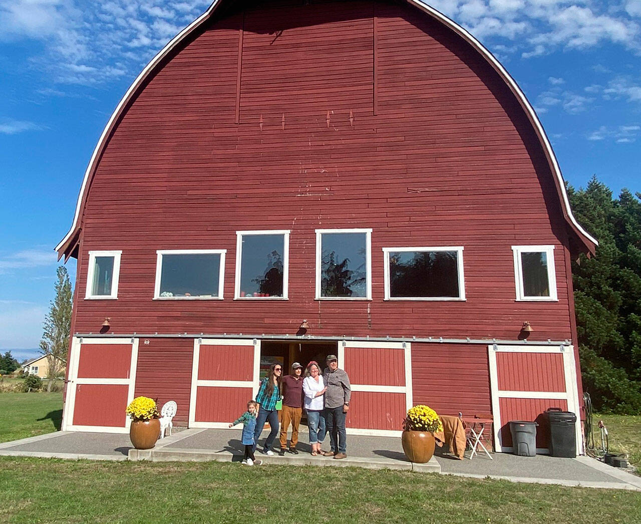 Photos courtesy Mary Beth Holladay
Family members, from left, five-year-old Ronin, Lindsay Holladay Van Damme, Chris Van Damme, and Mary Beth and Rick Holladay stand outside their barn — the Dungeness landmark Cline-Bigelow Barn — to celebrate its 90th birthday with family and friends.