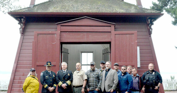 Photo by Elijah Sussman/Olympic Peninsula News Group / From left, Jefferson County Commissioner Heidi Eisenhour, Port Townsend Police Chief Thomas Olson, East Jefferson Fire Rescue Chief Bret Black, Jefferson County Sheriff Joe Nole, Mitchell Cartmel, Brandon Brown (back), Deputy Fire Marshal Brian Tracer, Andy Gosnell (back), Gabriel Shepherd, Ted Krysinski, Sam Neville and Officer Trevor Hansen stand in front of the Port Townsend Bell Tower on Sept 11.