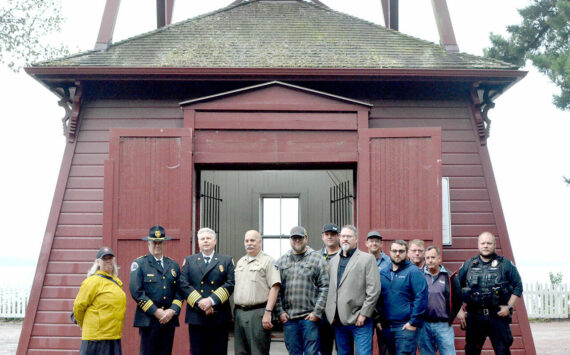 Photo by Elijah Sussman/Olympic Peninsula News Group / From left, Jefferson County Commissioner Heidi Eisenhour, Port Townsend Police Chief Thomas Olson, East Jefferson Fire Rescue Chief Bret Black, Jefferson County Sheriff Joe Nole, Mitchell Cartmel, Brandon Brown (back), Deputy Fire Marshal Brian Tracer, Andy Gosnell (back), Gabriel Shepherd, Ted Krysinski, Sam Neville and Officer Trevor Hansen stand in front of the Port Townsend Bell Tower on Sept 11.