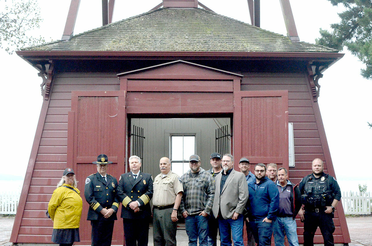 Photo by Elijah Sussman/Olympic Peninsula News Group / From left, Jefferson County Commissioner Heidi Eisenhour, Port Townsend Police Chief Thomas Olson, East Jefferson Fire Rescue Chief Bret Black, Jefferson County Sheriff Joe Nole, Mitchell Cartmel, Brandon Brown (back), Deputy Fire Marshal Brian Tracer, Andy Gosnell (back), Gabriel Shepherd, Ted Krysinski, Sam Neville and Officer Trevor Hansen stand in front of the Port Townsend Bell Tower on Sept 11.