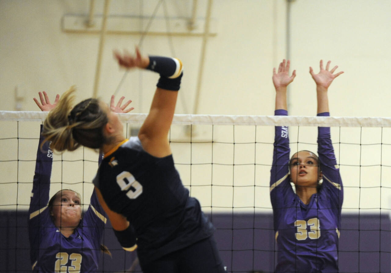 Sequim Gazette photo by Michael Dashiell / Sequim’s Kenzi Berglund, left, and Arianna Stovall look to block Bainbridge’s Holley McFadden in an Olympic League match in Sequim on Sept. 19.