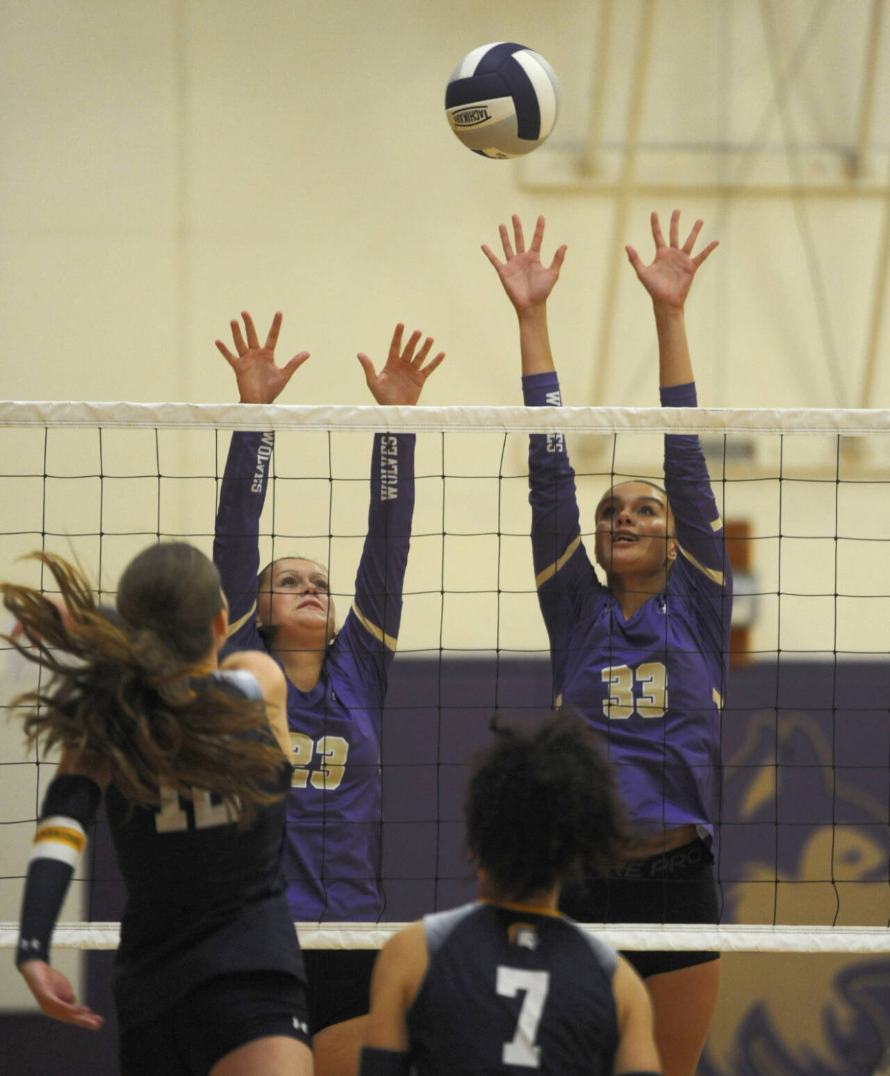 Sequim Gazette photo by Michael Dashiell. Sequim's Kenzi Berglund, left, and Arianna Stovall try to block Bainbridge's Elsa Wetzler during an Olympic League game in Sequim on Sept. 19.