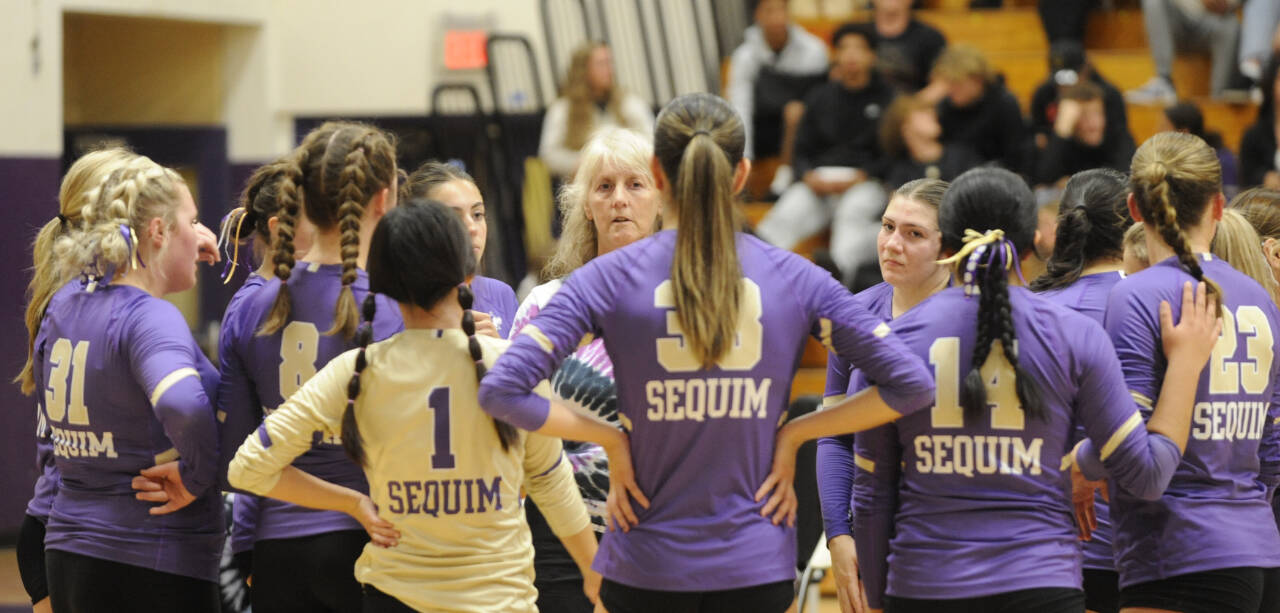 Sequim Gazette photo by Michael Dashiell / Sequim coach Jennie Webber Hielman (background) talks to players during a timeout in the first set as the Wolves face Bainbridge on Sept. 19.