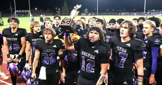 The Sequim Wolves celebrate winning the Rainshadow Rumble trophy in Sequim on Friday night. Sequim beat Port Angeles 27-7. (Michael Dashiell/Olympic Peninsula News Group)