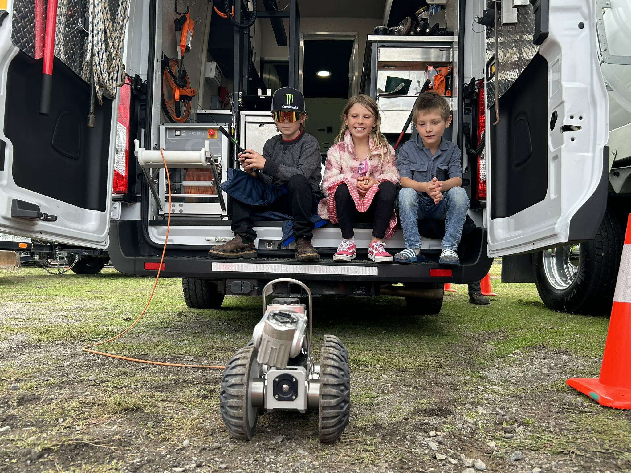 Sequim Gazette photo by Matthew Nash/ Skyler Neitzel, 8, gives the City of Sequim’s sewer camera a spin at the Sequim Public Safety Fair as Olivia, 7, and Winston Deal, 6, watch.