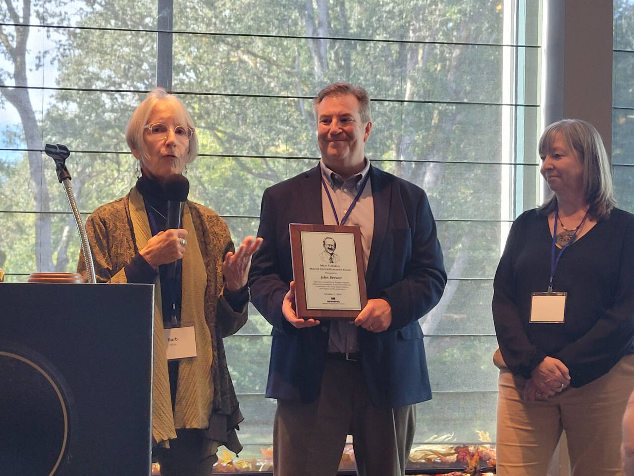 Sequim Gazette photo by Michael Dashiell / Barbara Wise, left, wife of former Peninsula Daily News editor/publisher John Brewer, accepts the Washington Newspaper Publisher Association’s Miles Turnbull Master Editor/Publisher award from WNPA president Sean Flaherty and WNPA executive director Ellen Hiatt at the associations’ annual conference in Olympia on Oct. 5.