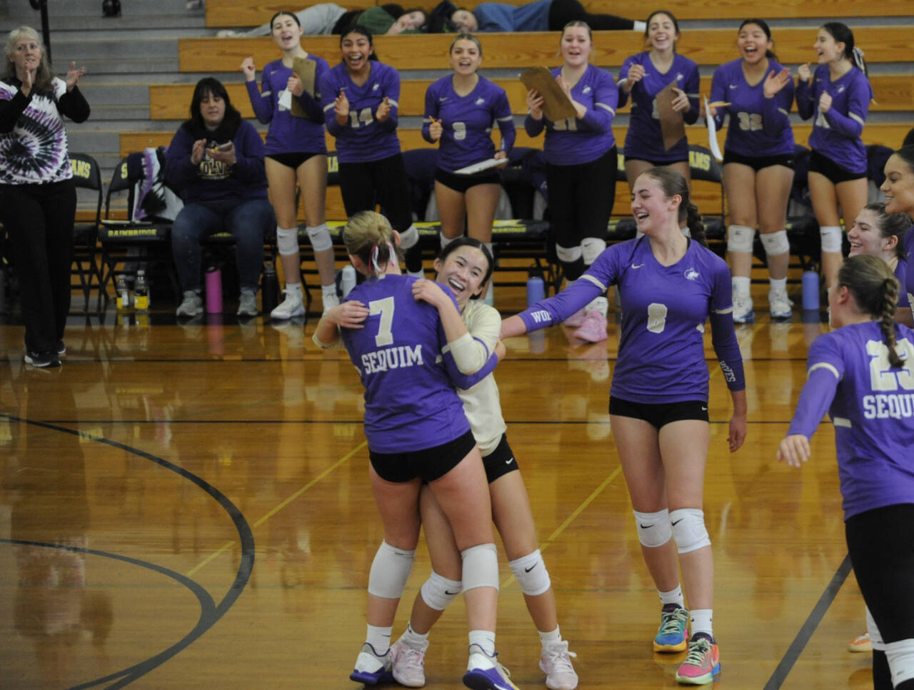 Sequim teammates congratulate libero Tiffany Lam after a spectacular effort led to a point in the Wolves’ Olympic League title game against Bainbridge on Nov. 2.