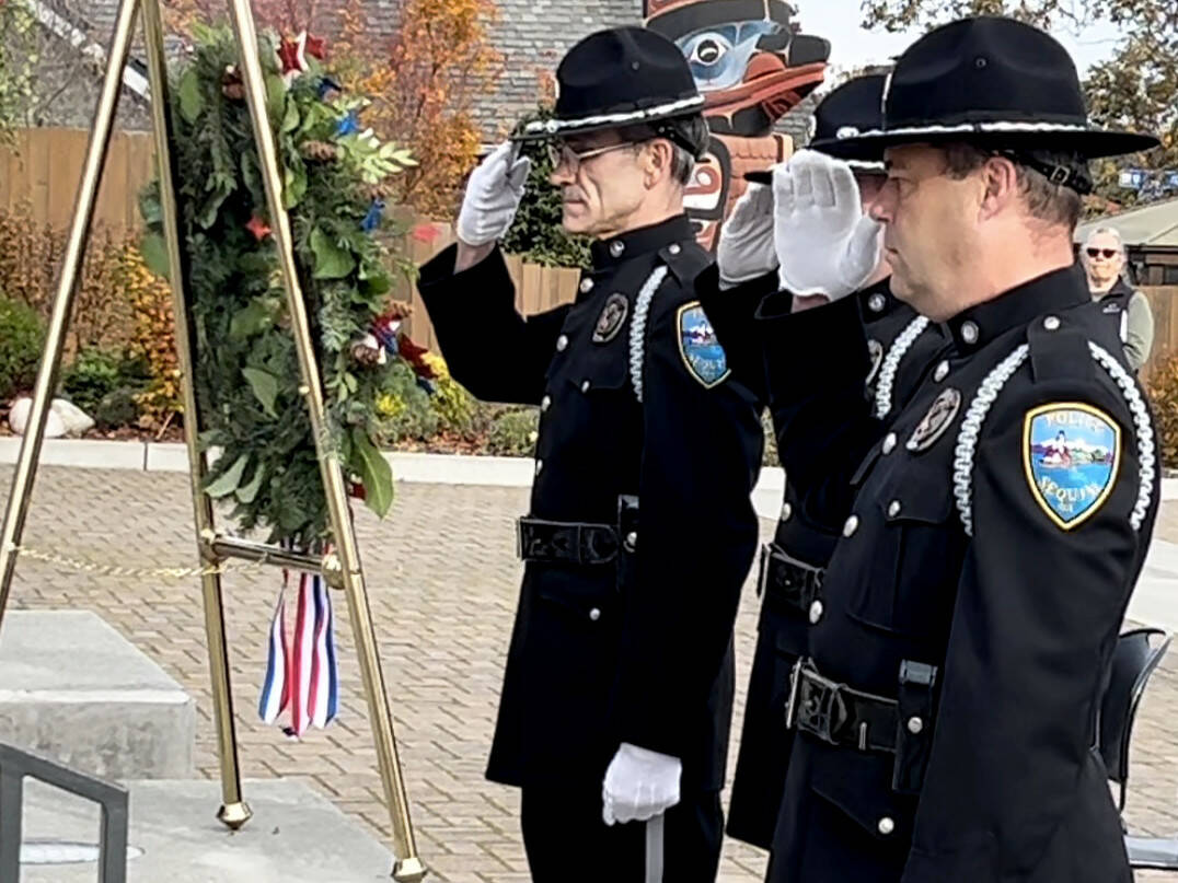 Sequim Gazette photo by Matthew Nash/ Sequim Police officers, from left, Mark Poole, Taran Johnson and Paul Dailidenas salute after placing a wreath to honor veterans on Nov. 8 at the City of Sequim’s flag poles during a ceremony. Poole is one of seven police officers on staff in the city who served in the military.