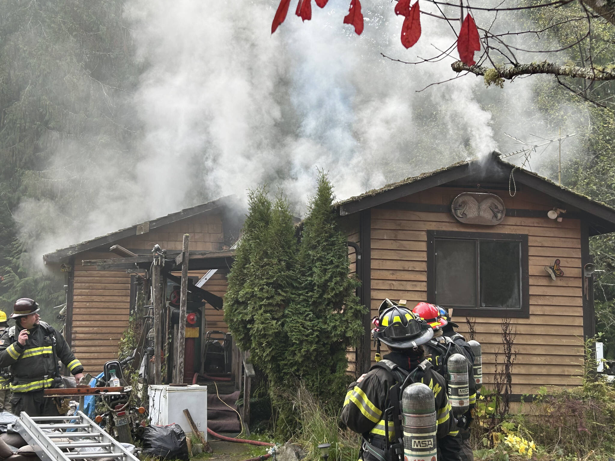 Sequim Gazette photo by Matthew Nash/ Clallam County Fire District 3 firefighters work to extinguish a fire Tuesday afternoon on the 100 block of Barnes Road.