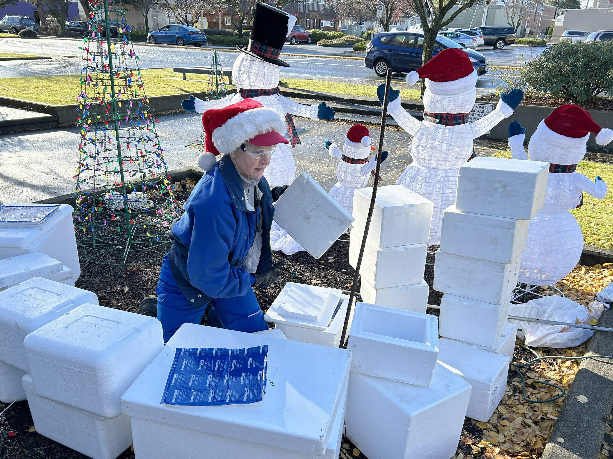 Sequim Gazette photo by Matthew Nash
Captain Crystal Stout stacks foam coolers to form an igloo for a snowman family on Nov. 20. She and other volunteers decorated the 1st Security Bank park and downtown Sequim throughout the week.