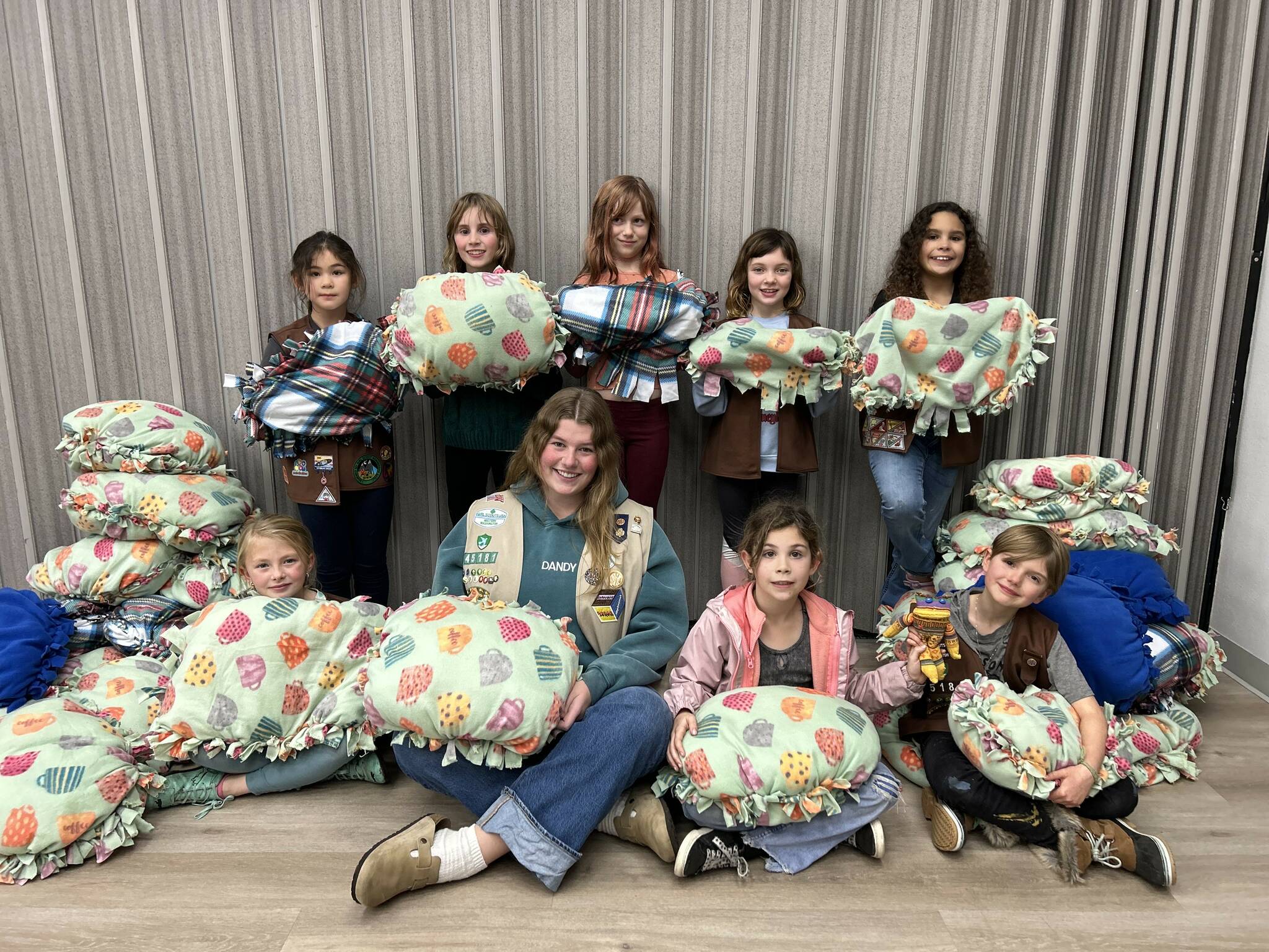 Photo courtesy Heidi Krzyworz 
Girl Scout in Troop 45181 hold pillows they made for Kitty City over several months after learning that the project went unfinished. The girls had made and donated up-cycled cat scratchers made out of Girl Scout cookie boxes earlier this year.