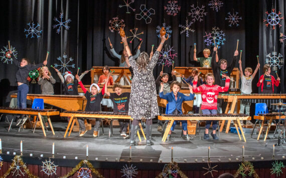 Sequim Gazette photo by Emily Matthiessen/ Five Acre School, a local non-profit elementary school, held their Winter Concert last Friday at Peninsula College under the direction of music and art teacher Rosie Sharpe. The children made the giant decorative wooden snowflakes.