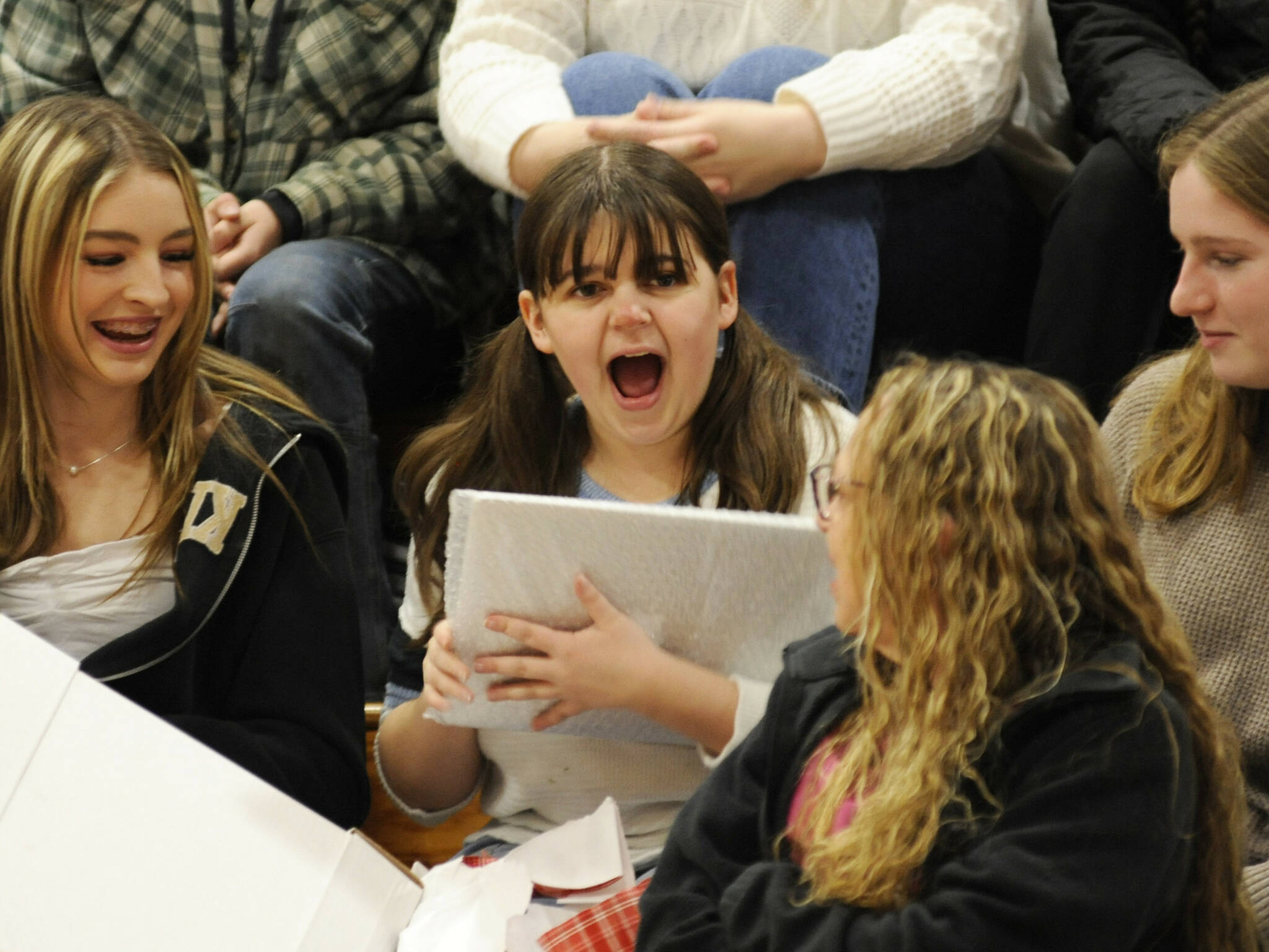 Sequim Gazette photo by Matthew Nash
Sequim High senior Sophia Treece shares her excitement with friends after receiving a new laptop for college at the Winter Wishes assembly on Dec. 18.