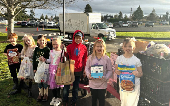 Photo courtesy Darcy Lamb 
Greywolf Elementary first graders in Rachel Peck and Cricket Hagan’s class, from left, Lucas Kroh, Dakota Joslyn-Crass, Oliver Vargas, Ruby Miller, Logan Tinkham, Autumn Glen, and Freya Welch stand with donations to Sequim Food Bank for 12 Days of Giving. School leaders said each class won an extra recess at least once for donating the most items each day.