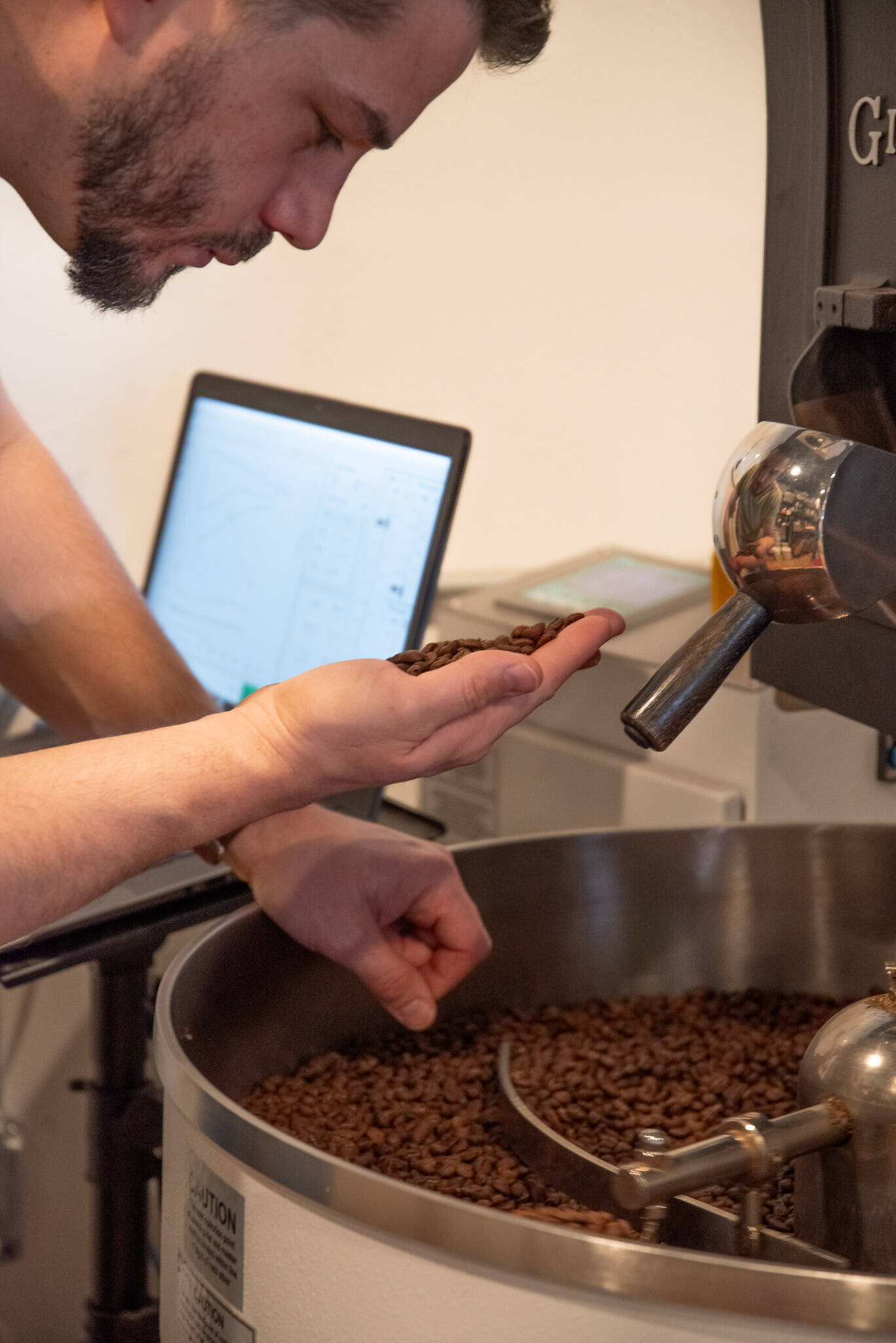 Sequim Gazette photo by Emily Matthiessen
Rod Dirks examines coffee beans over the roaster at Essence Coffee Roasters in Sequim.