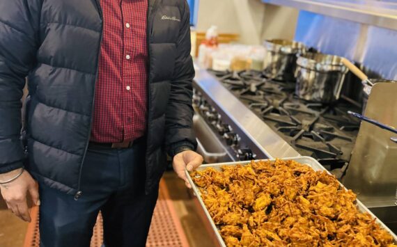 Sequim Gazette photo by Kathy Cruz 
Harinderbir Nagra, co-owner of Hardy’s Market, shows off a tray of onion bhaji, onion fritters seasoned with ginger and spices, as the store prepared to launch its new Indian food takeout menu last week.